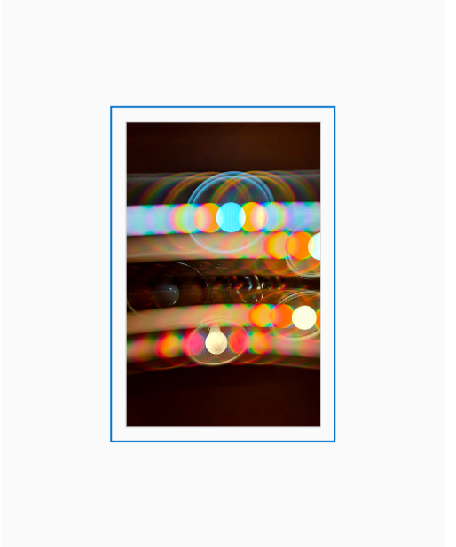 Diffraction grating photograph of a ceiling light in a home kitchen, rendered with warm spectral color across a domestic background.